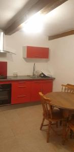 a kitchen with a wooden table and red cabinets at Maison de Village avec Jardinet à Revest du bion in Revest-du-Bion