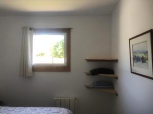 Schlafzimmer mit einem Bett und einem Fenster in der Unterkunft Gîte entre Golfe du Morbihan et Presqu'île in Surzur