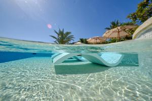a pool with a bench in the water at La Moraleja The Quiet Hotel - Adults Only in Cala de Sant Vicenc