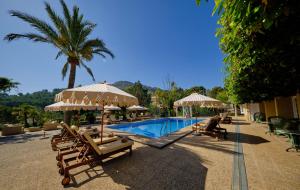 einen Pool mit Stühlen und Sonnenschirmen neben einem Resort in der Unterkunft La Moraleja The Quiet Hotel - Adults Only in Cala de Sant Vicent