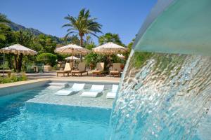 una piscina con sillas y sombrillas en un complejo en La Moraleja The Quiet Hotel - Adults Only en Cala de Sant Vicent