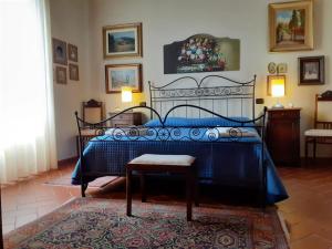 a bedroom with a black bed with a bench and a rug at Fattoria Michela in Matraia