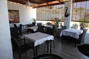 ein Restaurant mit Tischen und Stühlen mit weißem Tischtuch in der Unterkunft A treat away from home The Dragonfly Villa in Coín