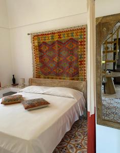 a bed with two pillows on it in a room at Dammuso Pensare alla Luna in Pantelleria
