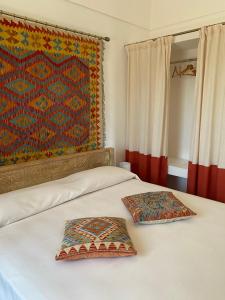 2 poduszki siedzące na łóżku w sypialni w obiekcie Dammuso Pensare alla Luna w mieście Pantelleria