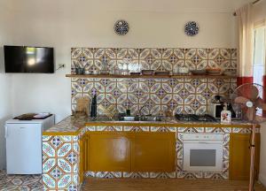a kitchen with a sink and a counter with tiles at Dammuso Pensare alla Luna in Pantelleria
