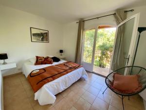 a bedroom with a bed and a large window at Villa vue mer donnant sur le Golfe de St Tropez, 2 chambres, 6 pers, piscine commune in Saint-Tropez