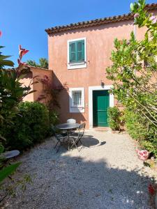 a table in front of a building with a green door at Villa vue mer donnant sur le Golfe de St Tropez, 2 chambres, 6 pers, piscine commune in Saint-Tropez