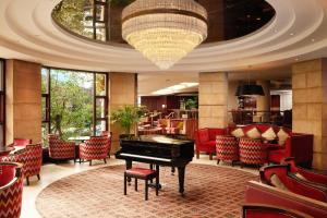 a living room filled with furniture and a piano at Europa Hotel in Belfast