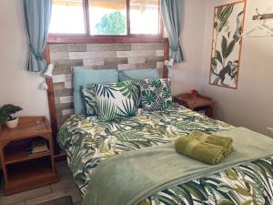 a bedroom with a bed with a green comforter at Waves Of Witsand in Witsand
