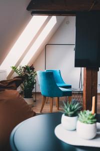 a room with a table and a blue chair at ATRIO Apartments 2 in Trenčín