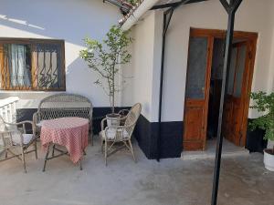 a patio with chairs and a table with a tree at The Fir Gate in Gjirokastër