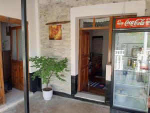 a shop with a cocacola sign on the side of a building at The Fir Gate in Gjirokastër