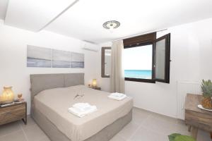A bed or beds in a room at Seafront Villa Eirini