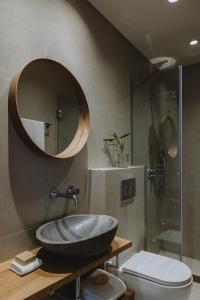 y baño con lavabo, espejo y aseo. en Nama Seaside Villas, en Paralia Kanaliou