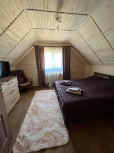 a bedroom with a bed and a couch in a attic at На Березові in Krivorovnya