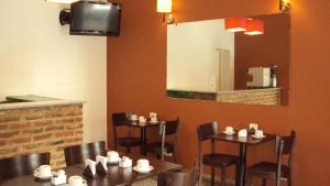 - une salle à manger avec des tables, des chaises et un miroir dans l'établissement Hotel Aries Palermo, à Buenos Aires