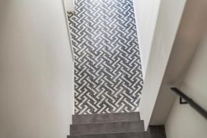 a stairway with a geometric patterned wall at Design Studio Gent modern en stijlvol met terras in Ghent