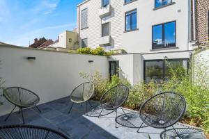 a group of chairs sitting on a patio at Design Studio Gent modern en stijlvol met terras in Ghent