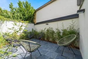 a patio with three chairs and a fence at Design Studio Gent modern en stijlvol met terras in Ghent