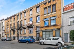 two cars parked in front of a brick building at Design Studio Gent modern en stijlvol met terras in Ghent