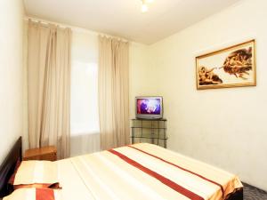 モスクワにあるApartLux Sokolnicheskaya Two Roomsのベッドとテレビが備わるホテルルームです。