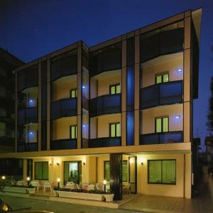 un gran edificio con luces azules por la noche en Hotel Urbinati, en Bellaria-Igea Marina