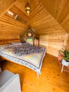 a bedroom with a bed in a wooden room at The Hobbit Hole in Zelah