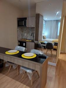 カンポス・ドス・ゴイタカゼスにあるFLAT Pelinca Américaのキッチン、リビングルーム(テーブル、椅子付)