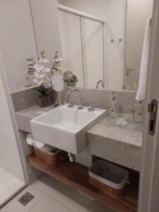 a bathroom with a sink and a mirror at FLAT Pelinca América in Campos dos Goytacazes
