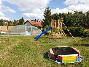 un parco giochi con scivolo e altalena di Ferienhaus Hlidek a Nová Lhota