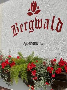 a sign on a building with red flowers on it at Bergwald in Alpbach