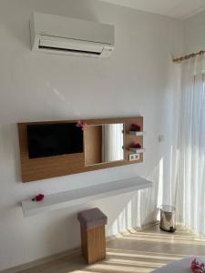 uma sala de estar com uma televisão na parede em Talay Pansiyon em Kas