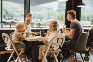 a family eating at a table in a restaurant at Bretterhotel in Brienz