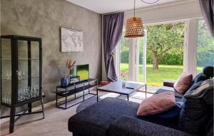 a living room with a blue couch and a tv at Pet Friendly Home In Ytterby With Kitchen in Ytterby