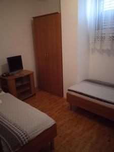 a bedroom with two beds and a desk with a computer at Turistična kmetija Birsa in Dobravlje