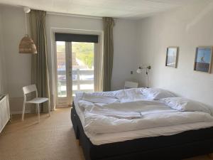 1 dormitorio con 1 cama grande y ventana en Hotel Klitbakken, en Løkken