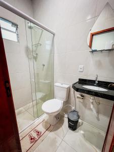 a bathroom with a toilet and a shower and a sink at Pousada Serrana in Serra de São Bento
