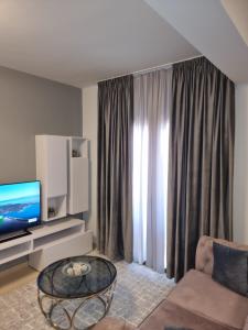 a living room with a couch and a television at Melina's house in Barbati