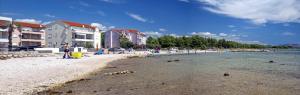 a group of people on a beach with buildings at ERE Apartment in Srima