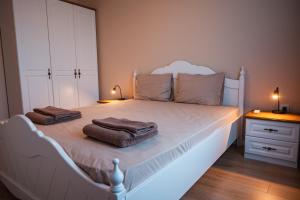 a bedroom with a white bed with two towels on it at EMERALD SUITE with private parking in Varna City