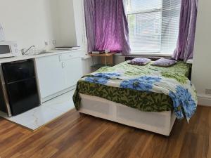 a small bedroom with a bed and a kitchen at Lovely Studio flat in London in London