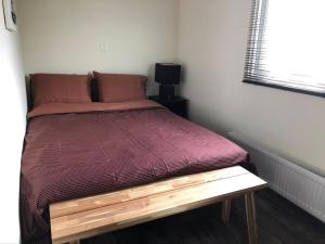 een bed met een houten frame in een kamer bij Vakantiehuis “Het Zeepaard” in Voorthuizen