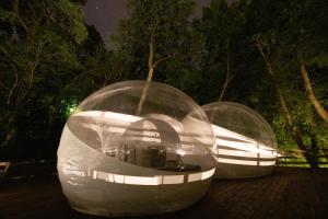 deux sphères en forme de dôme assises sur une terrasse la nuit dans l'établissement Nomád Glamping, à Noszvaj