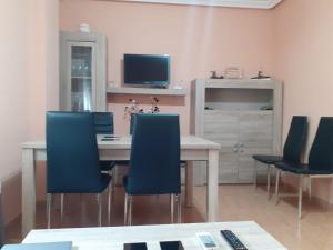 a dining room with a table and blue chairs at Casa Carla in Sotoserrano