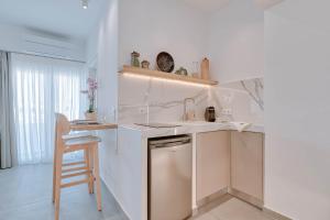 uma cozinha com um lavatório e um balcão com um banco em Nautica suites - Executive suite with jacuzzi em Antiparos Town