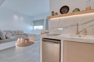 uma cozinha e sala de estar com um lavatório e um sofá em Nautica suites - Executive suite with jacuzzi em Antiparos Town