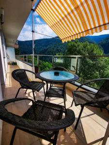 a patio with a table and chairs on a balcony at Orchid Luxury Apartment Sinaia in Sinaia
