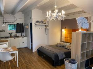 a bedroom with a bed and a table and a chandelier at Vakantiehuisje De Waterhoek in Geel