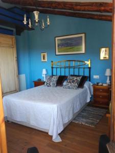 a bedroom with a large bed with blue walls at Casa Rural la Escalera in Letur